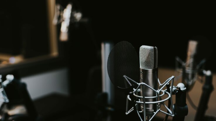 Fotografie eines Mikrofons im dunklen Raum eines Studios.