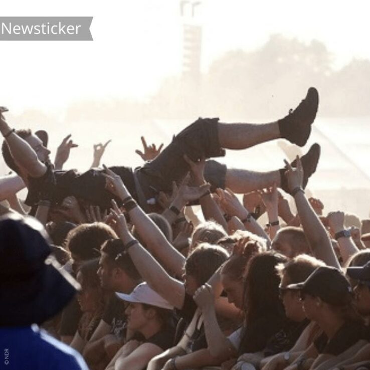 Ein Mann crowdsurfed bei einem Festival.